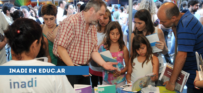 Fotografía de niñas mirando libros en un stand del INADI