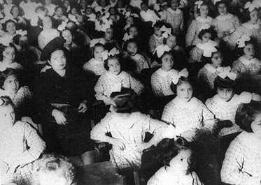 Las niñas con sus impecables moños blancos, en el salón de actos.