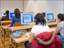 Fotografía de alumnos utilizando computadoras en un aula.