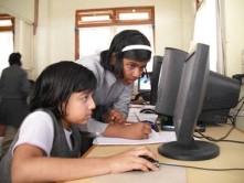 Fotografía de dos alumnos trabajando en clase con sus computadoras.