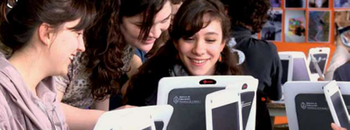 Chicas aprendiendo a manejar un programa en sus netbooks. En color.