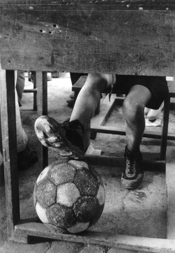 Fotografía de los pies de un niño con un balón de fútbol